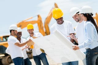 Group of architects at a construction site looking at blueprints .jpeg