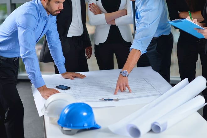 business people group on meeting and presentation in bright modern office with construction engineer architect and worker looking building model and blueprint plans.jpeg