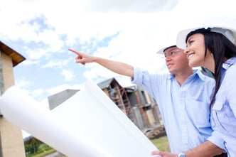 Couple looking at their new house and holding blueprints.jpeg